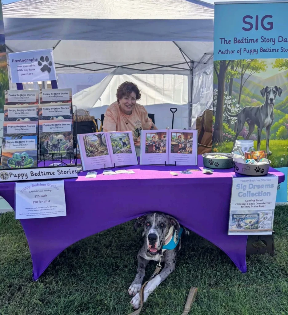Great Dane puppy laying under his book table at a festival